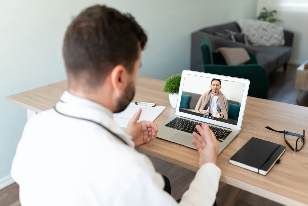 man consults doctor via telemedicine video call utc
